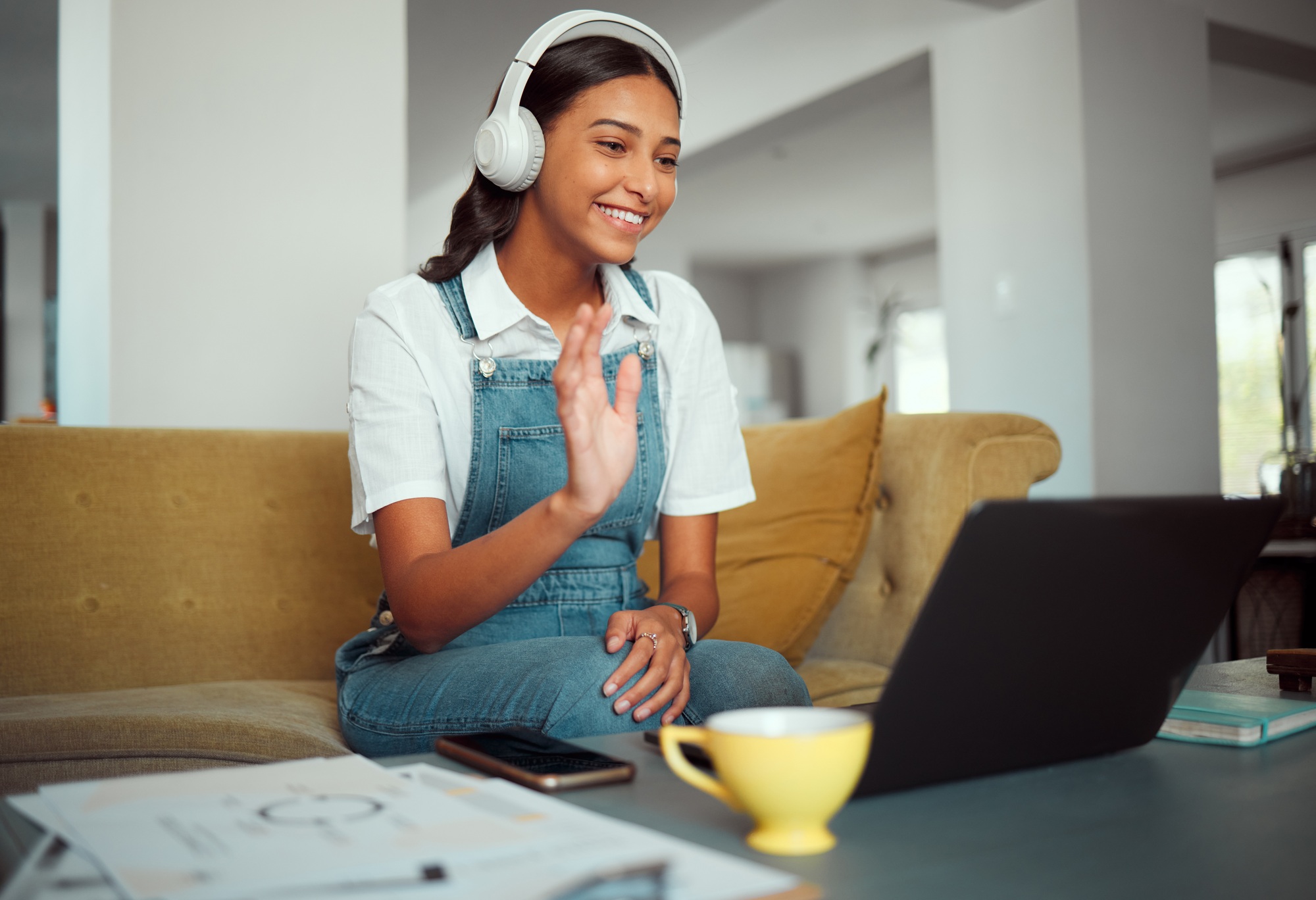 Video call, laptop and wave with woman on sofa for communication, internet and connection. Relax, s